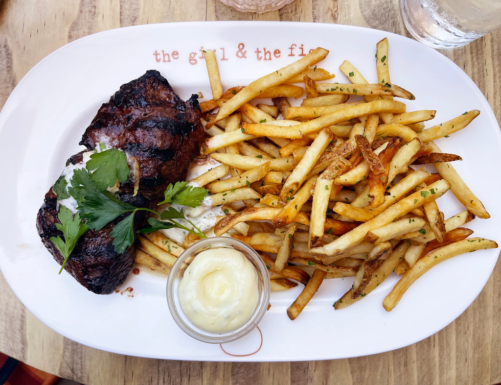 An image of steak frites served with hollandaise sauce. 