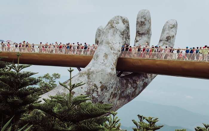 An image of tourists crossing the Golden Bridge of Da Nang.