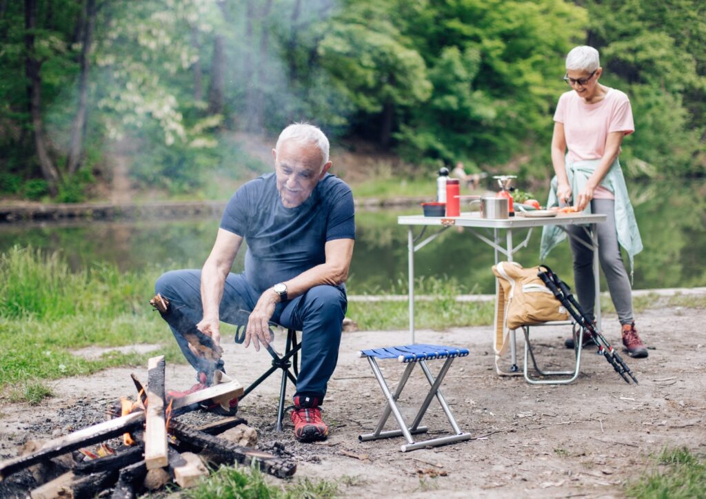 A senior couple cooking while camping.