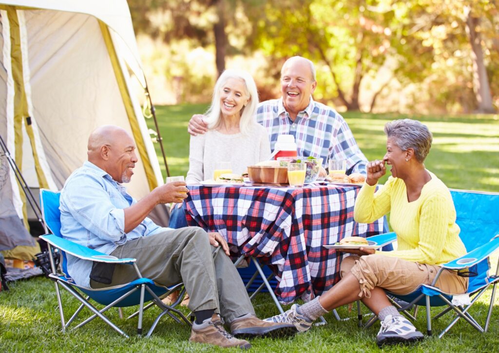 A group of senior enjoying nature while camping.