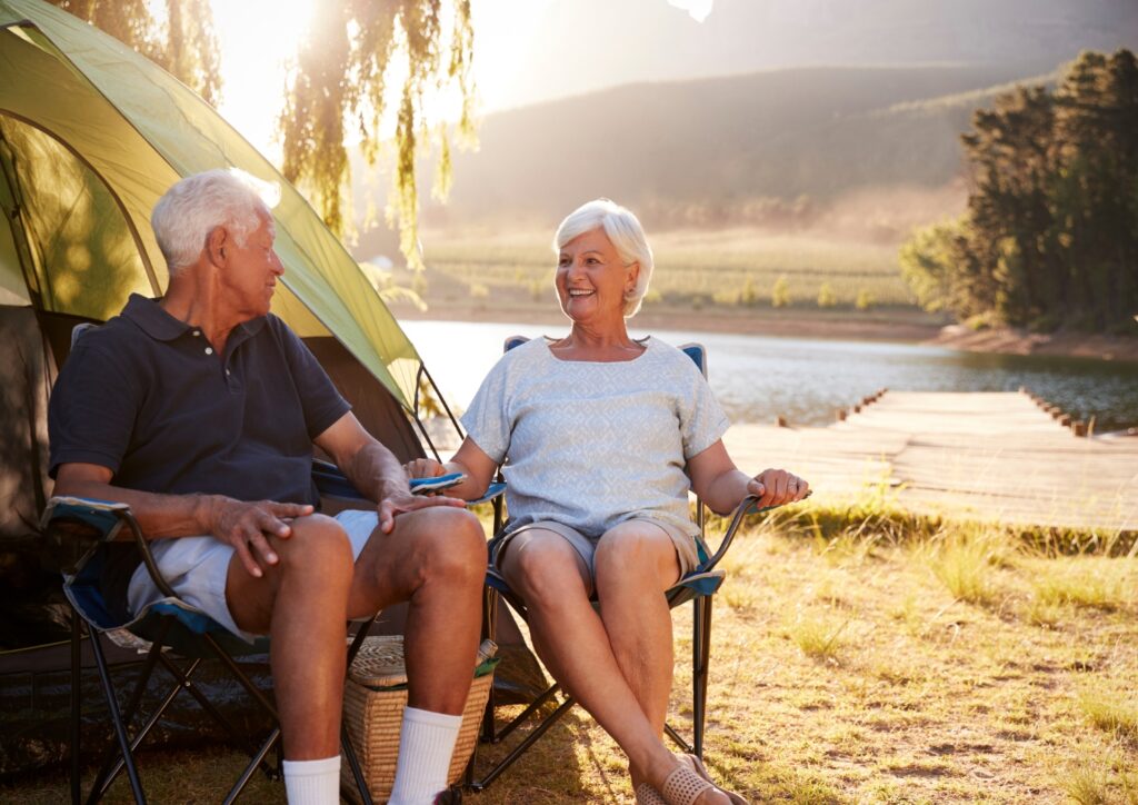 An image of a senior couple enjoying nature while camping.
